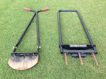 A black step edger and a black coring aerator on the lawn.
