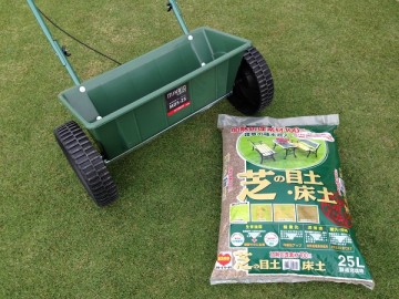 A seed spreader and a top-soil on the lawn. Top-Soil/Bed-Soil for Lawn, 25 L, by Tachikawa-Heiwa.