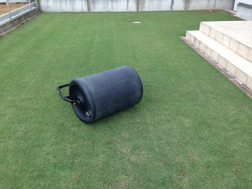 A black roller on the lawn. The Baroness Lawn Flattening Roller.