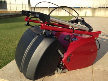 The mowing machine whose handle was folded. Together with the tile deck and lawn.