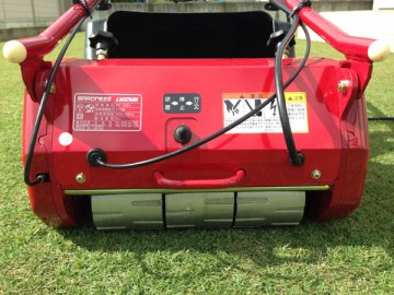 Back side of the mower. Aluminum drum wheels and a reverse switch.