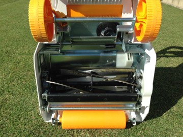 The other side of the mower. A black reel type five-blade attached to a mower in white and yellow.