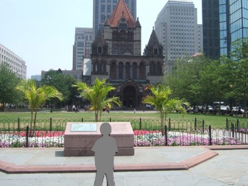 A photo of a child, with a lawn in front of Copley Square and Trinity Church in behind.