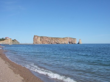 A massive rock with a hole in it. Percé Rock in the village of Percé in Gaspé Peninsula.