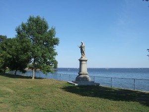 Alongside Lakeshore Road. Lawn and a statue in front of Lake Saint-Louis.