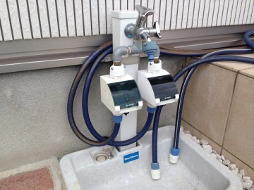 立水栓に接続された2つのタカギの「かんたん水やりタイマー」。