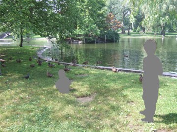 パブリック・ガーデンの湖の水際のカモの群れ。手前に2人の子供。